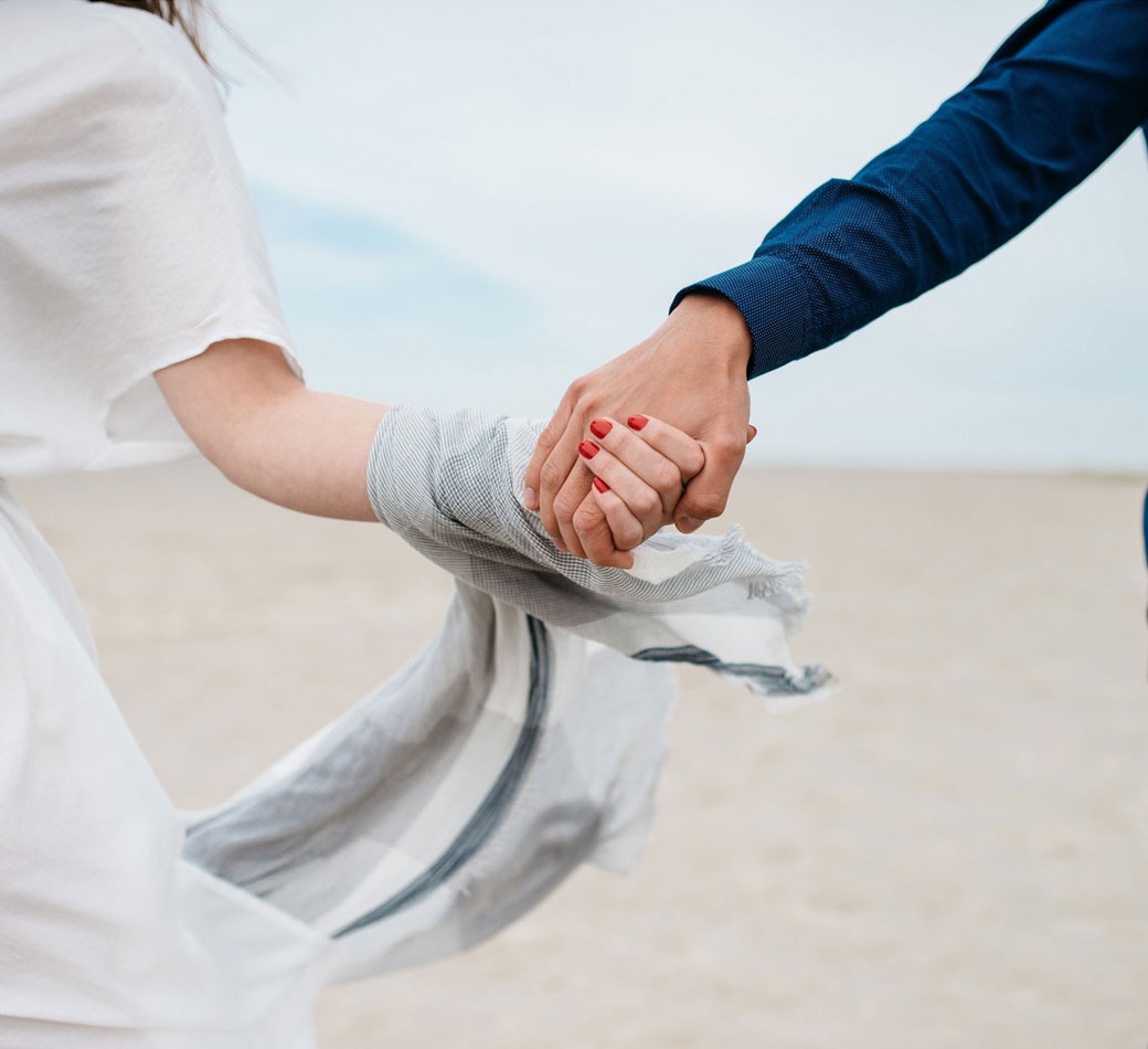A couple holding hands on a beach