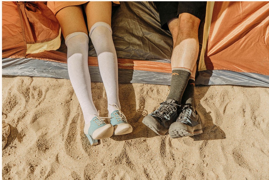 A couple relaxing in front of a tent on the sand